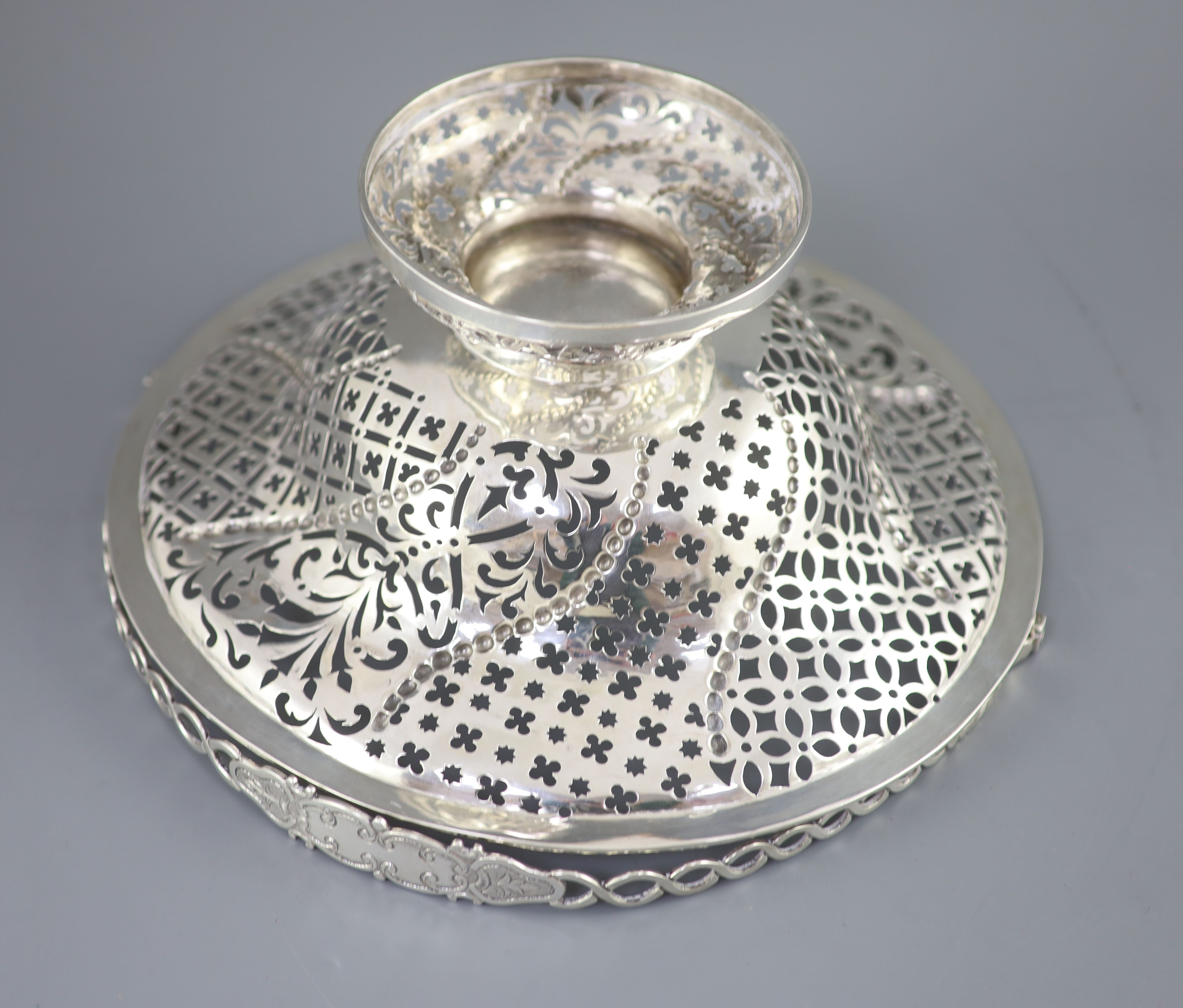A George III pierced silver pedestal bread basket, with oval ring swing handle,